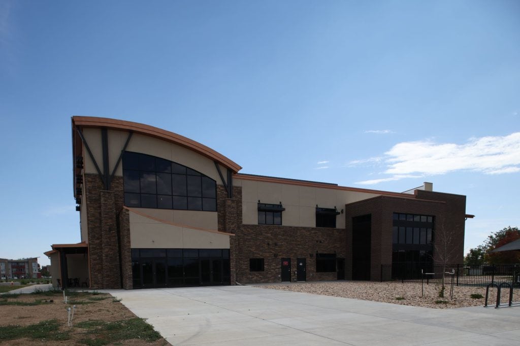 Stillwater Church front entry with curved standing-seam roof and glass narthex, Loveland CO